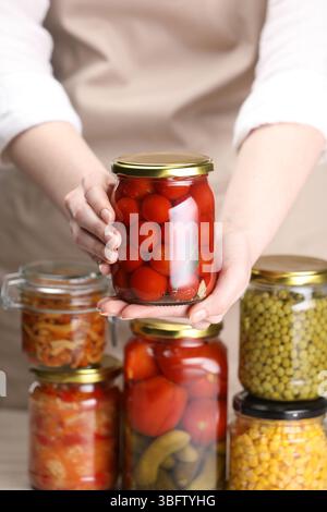 Woman with many jars of different pickled products, closeup Stock Photo
