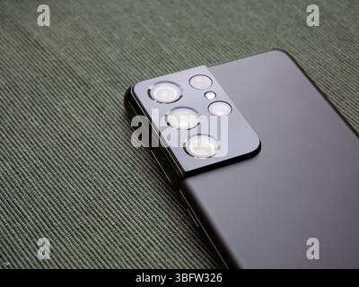 Closeup of a SGS 21 Samsung Galaxy S21 Ultra smartphone back part with multiple camera lenses macro view of a mobile phone quad camera module and matt Stock Photo