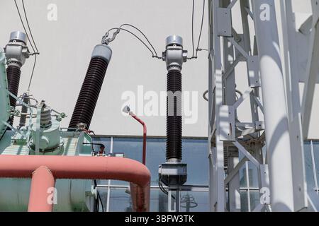 Close-up of high-voltage insulators and electrical components at an outdoor power substation. High quality photo Stock Photo