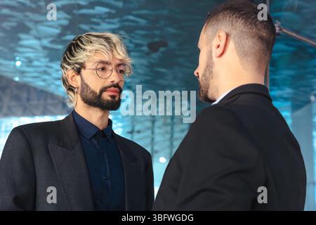 Two businessmen in serious conversation inside modern office with glass walls Stock Photo