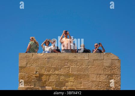 Tourists photo, view of a group of tourists taking photos from a tower sited in the historic Citadel (Cittadella) fort in Gozo, Malta Stock Photo