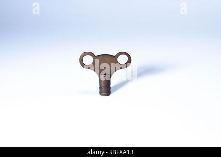 Metal radiator key isolated on a white background, used for bleeding radiators in home heating systems. Stock Photo