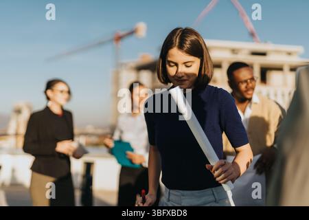 Multicultural business team enjoying a rooftop break at sunset Stock Photo