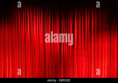 Red velvet curtain closing on a dark stage, perfect for entertainment or theatre concepts Stock Photo