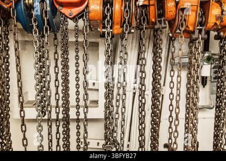 Chain hoists for lifting weights in a workshop close-up. Stock Photo