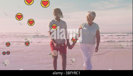 Image of falling hearts over african american senior couple on the beach Stock Photo