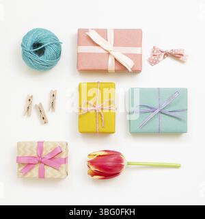 Colorful gift boxes with red tulip flower isolated on white background. Flat lay, top view Stock Photo