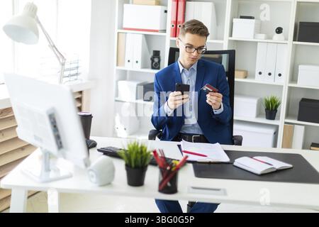 Casual businessman working in office, sitting at desk, typing on keyboard, looking at computer screen Stock Photo