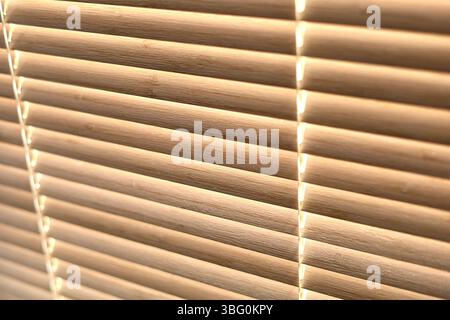 Close up texture of the closed bamboo window blinds with light shining from behind. Side view Stock Photo