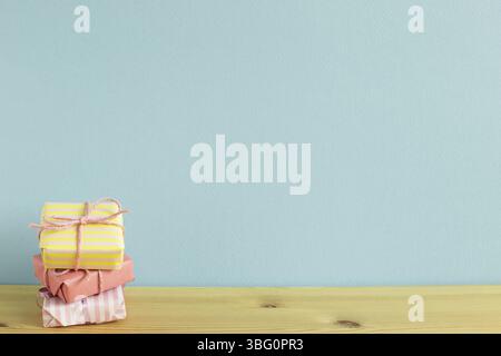 Colorful gift boxes on wooden table. sky blue background Stock Photo