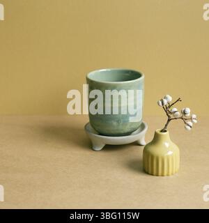 Ceramic tea cup with dry plant on brown table background Stock Photo
