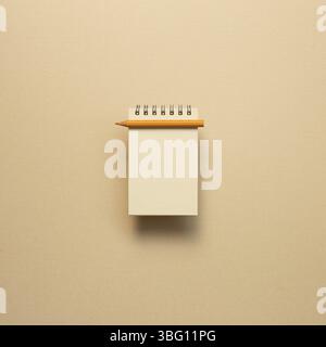 Empty kraft notepad with colored pencil on beige background. top view, copy space Stock Photo