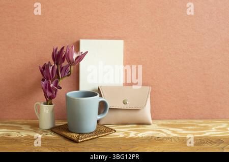 Notebook, mug cup, flower, wallet on wooden desk. red background. Work and study place Stock Photo