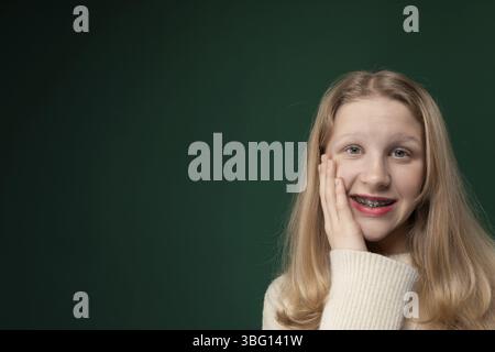 A woman with flowing long blonde hair striking a confident pose for a portrait. Her hair cascades down her shoulders as she smiles for the camera, exu Stock Photo