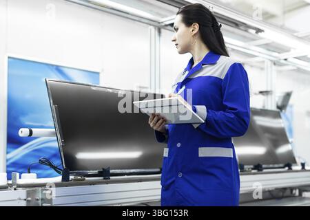 Conveyor for the production of television sets. Testing TVs in the workshop. Electronics Assembly Line Stock Photo