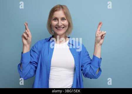 Energetic 50s woman in an attractive look on a blue background with copy space Stock Photo