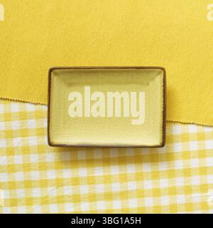 Empty plate on yellow fabric background. top view Stock Photo