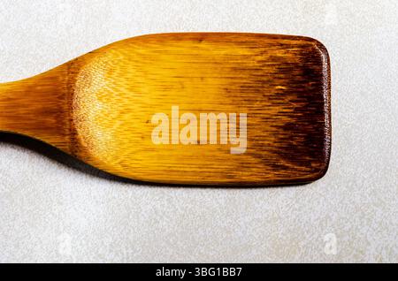 horizontal single weathered wooden spatula on a gray patterned background Stock Photo