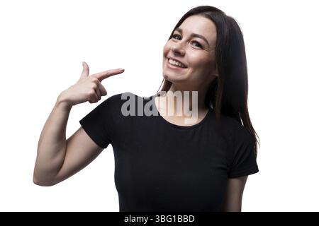 Young smiling european woman dressed in basic t-shirt pointing with finger Stock Photo