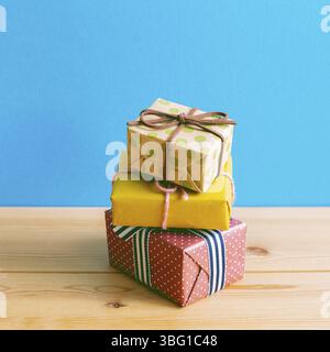 Colorful gift boxes on wooden table with blue background Stock Photo