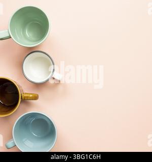 Colorful empty mug cups on pink background. top view Stock Photo