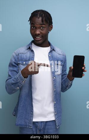 Smiling african man with black dreadlocks using smartphone Stock Photo