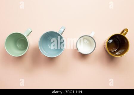 Colorful empty mug cups on pink background. top view Stock Photo