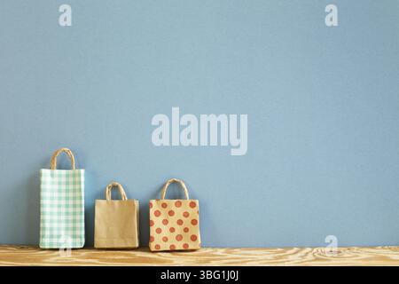 Colorful paper shopping bags on wooden table. blue background Stock Photo
