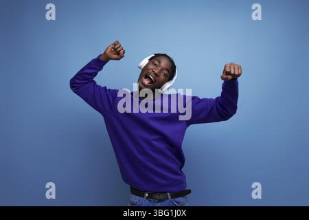 American young man with dreadlocks dancing to music with headphones Stock Photo