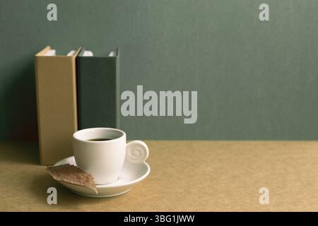Notebook and cup coffee on brown desk. green wall background. retro style Stock Photo