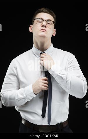Young caucasian elegant smart business man in white shirt standing in office looking in camera waiting for a client tightening tie Stock Photo