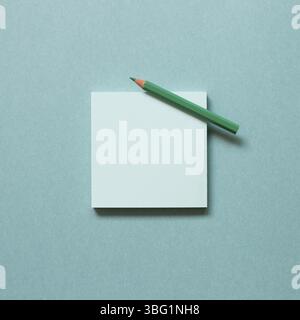 Green memo paper, sticky notes with colored pencil on green background. top view, copy space Stock Photo