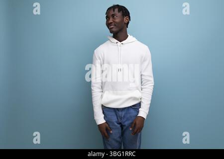 Active american young man with dreadlocks in a white sweater inspired on a blue background Stock Photo