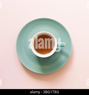 Mint color tea cup isolated on pink background. top view Stock Photo