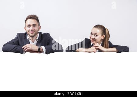 Studio portrait on white background of successful business men and women in business suits next to the board for advertising which could be your text Stock Photo