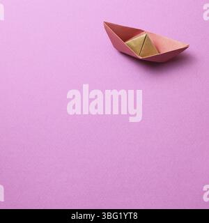 Paper ship on pink background Stock Photo