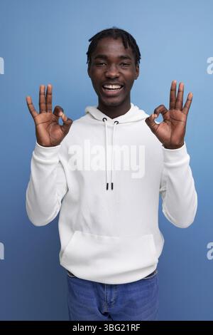 Positive dark skinned young brunette male with hollywood smile on studio isolated background Stock Photo