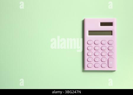 Pink digital calculator on green background Stock Photo