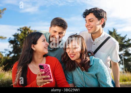 Group of young students using mobile phone in a park Stock Photo