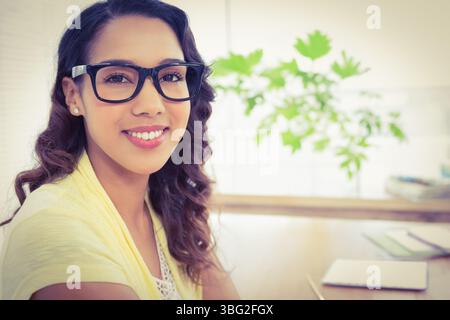 Tablet and stacked notebooks are resting on desk near potted plant under diffused window light Stock Photo