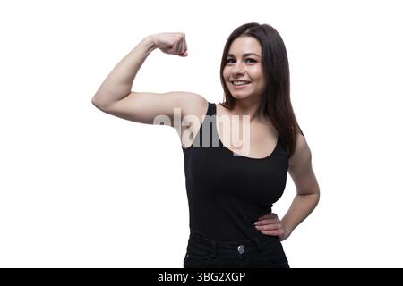 Happy young stylish woman with black hair showing strong muscles Stock Photo