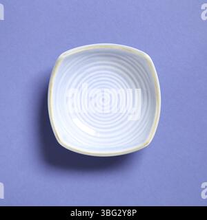 Blue dish isolated on purple background Stock Photo
