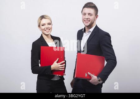 Two businessmen the man and woman with red office folders on a white background Stock Photo