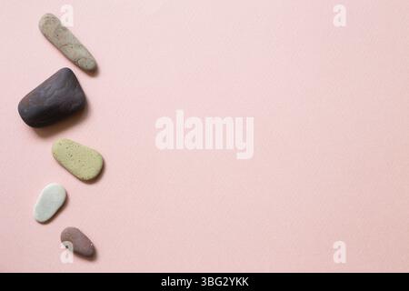 Natural pebble stones on pink background. top view, copy space Stock Photo