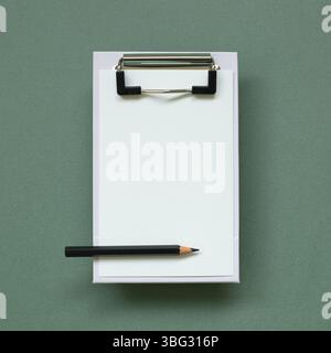 Clipboard and paper sheet on green background. top view, copy space Stock Photo