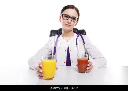 Portrait of young attractive caucasian brunette positive friendly smiling woman nutritionist sitting in office with glass of fresh juice in her hands Stock Photo