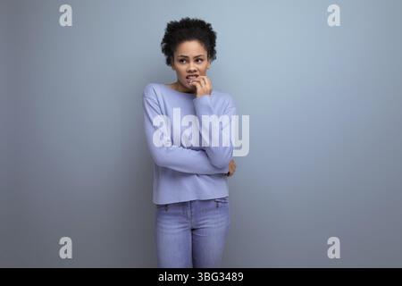 Close up of pretty young 20s woman with dark puffy hair isolated background with copy space Stock Photo