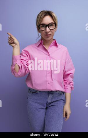 Young smart blond caucasian secretary woman with glasses and ponytail dressed in a pink blouse Stock Photo