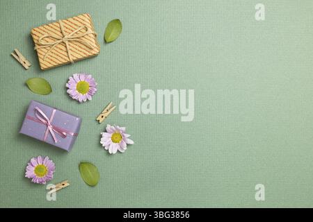 Gift boxes with flowers on green background. flat lay, top view, copy space Stock Photo