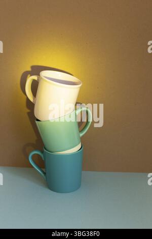 Three cups on blue table. brown wall background Stock Photo